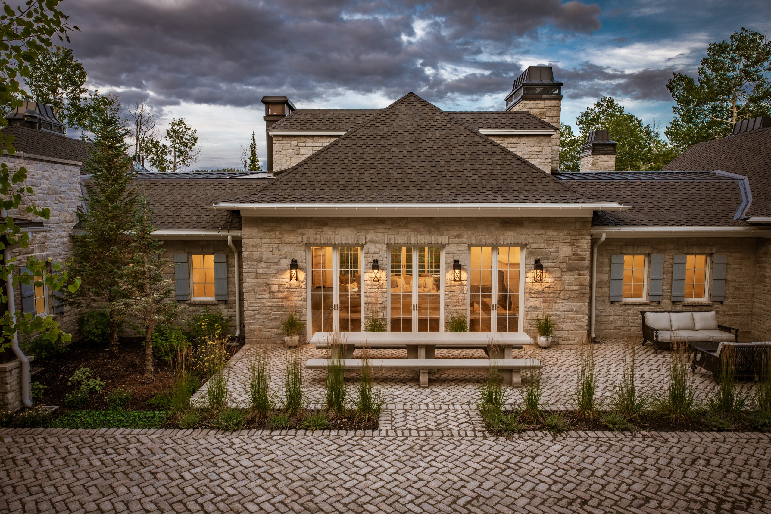 Traditional stone home under a storm sky at dusk